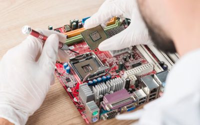male-technician-inserting-chip-computer-motherboard-wooden-desk