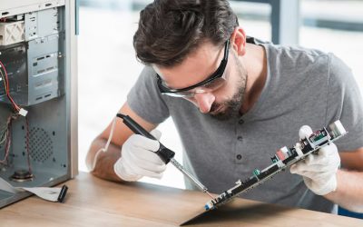 young-man-soldering-computer-circuit-wooden-desk